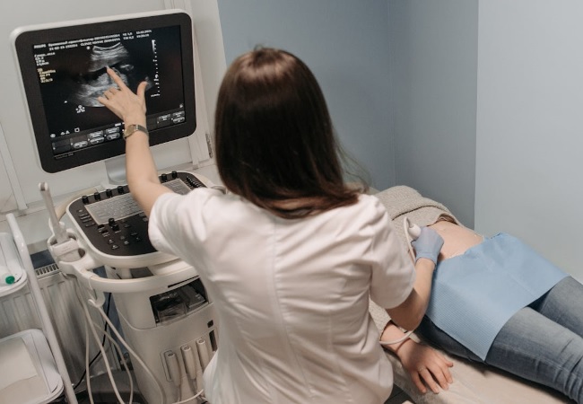 Sonographer performing a gender reveal ultrasound scan on a pregnant woman